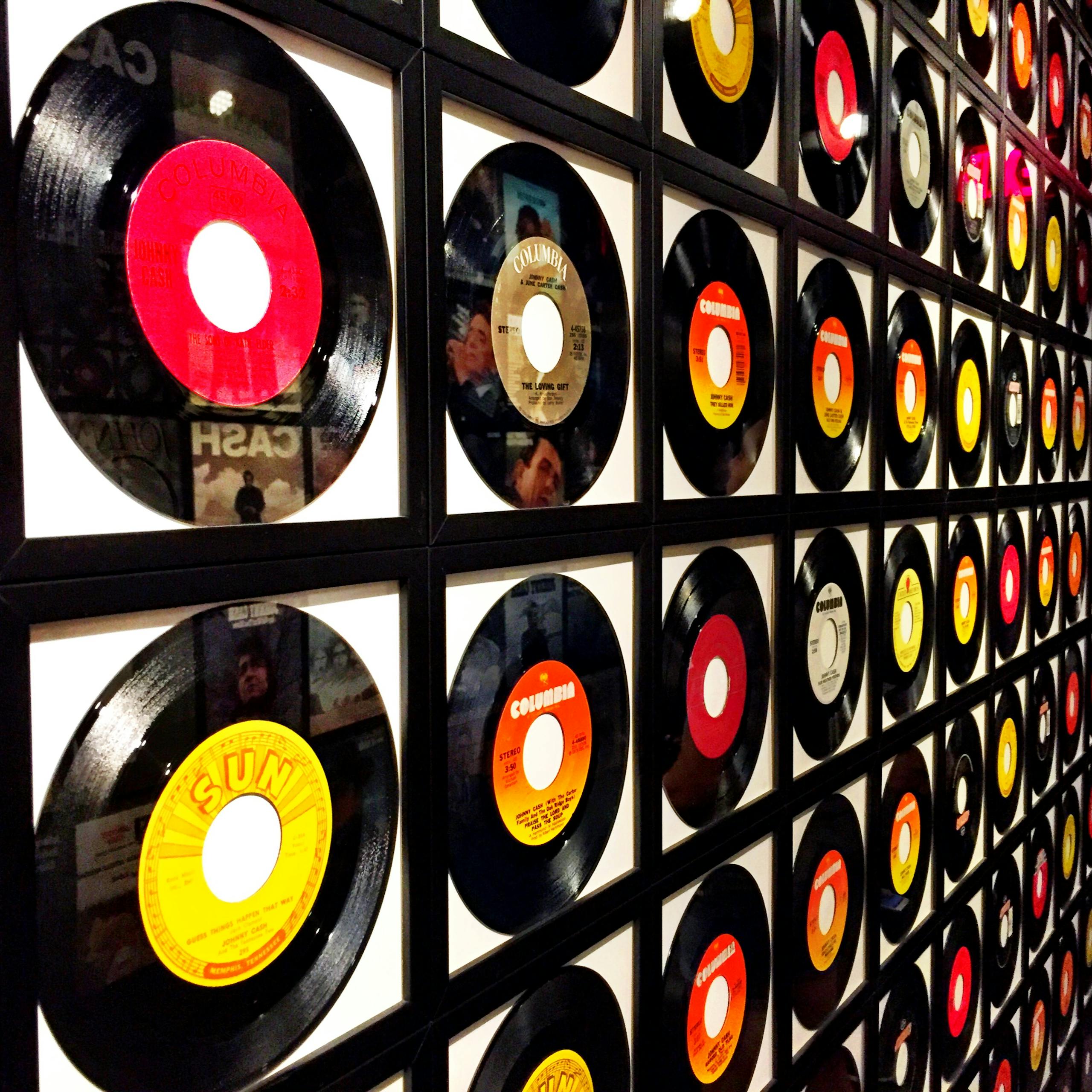 Colorful vinyl records framed and displayed on a wall, showcasing a retro music theme.